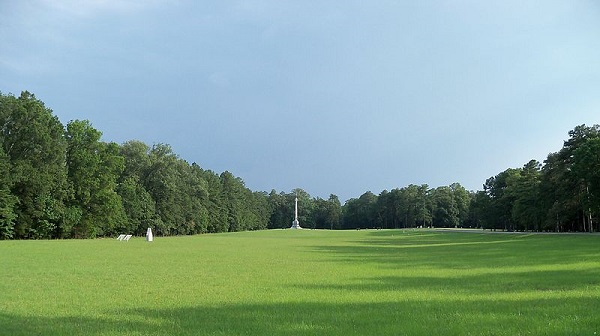 Green lawn with battle monuments. Trees at the edges of the lawn