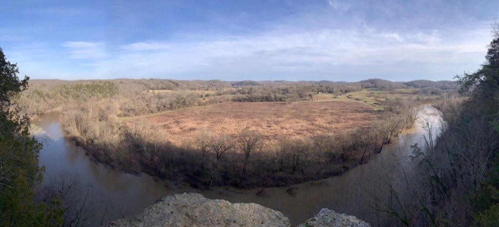 Aerial view of river bend in a wooded area with fall colors