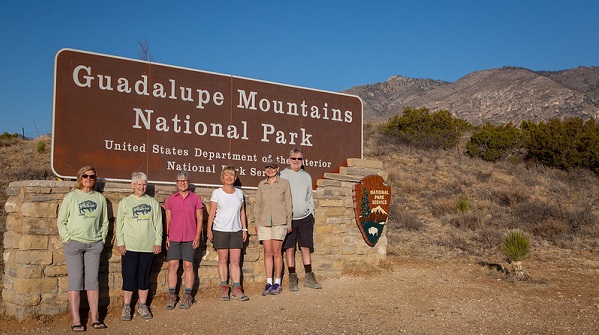 Six people standing in front of the Guadalupe Mountains National Park Sign