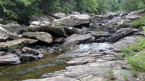 View of a rocky creek bed with water flowing through