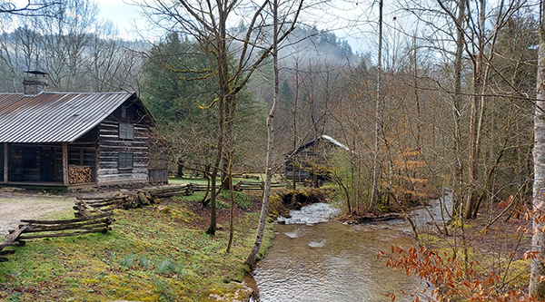 view of lodge on creek in wooded area in late fall or early winter